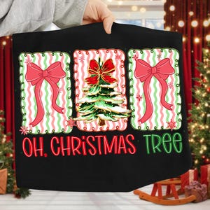 May include: Black Christmas-themed graphic featuring three rectangular designs. The designs include red bows, a Christmas tree, and the text "OH, CHRISTMAS TREE" in red and green. The background has a red and green striped pattern.