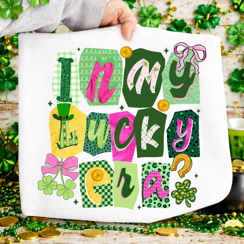 May include: White St. Patrick's Day themed towel with the phrase "I'm my lucky era" in colorful, patterned letters. The design includes shamrocks, a horseshoe, and a leprechaun hat. The towel is held up by a person.
