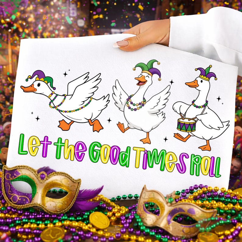 May include: A white sign with three cartoon geese wearing jester hats and beaded necklaces. The geese are dancing, and one is playing a drum. The sign reads "Let the Good Times Roll" in colorful letters. Mardi Gras masks and beads are in the foreground.