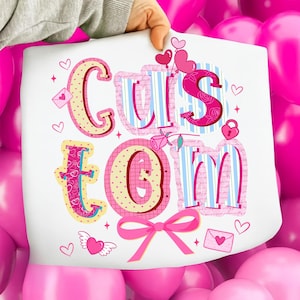 May include: A white sheet with the word "Custom" in a colorful, decorative font. The letters are pink, blue, and yellow, with heart and bow accents. The sheet is held up against a background of pink balloons.