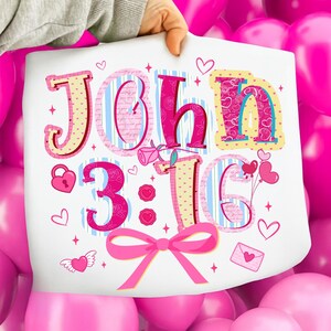 May include: A white print with the words "JOHN 3:16" in a decorative font. The design incorporates hearts, a bow, and other romantic elements. The background features pink and blue stripes, creating a vibrant aesthetic.
