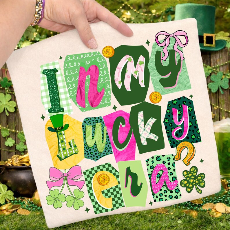 May include: A cream-colored pillow with the words "I'm in my lucky era" in a colorful, whimsical design. The design includes green, pink, and gold accents, with shamrocks, bows, and a leprechaun hat.