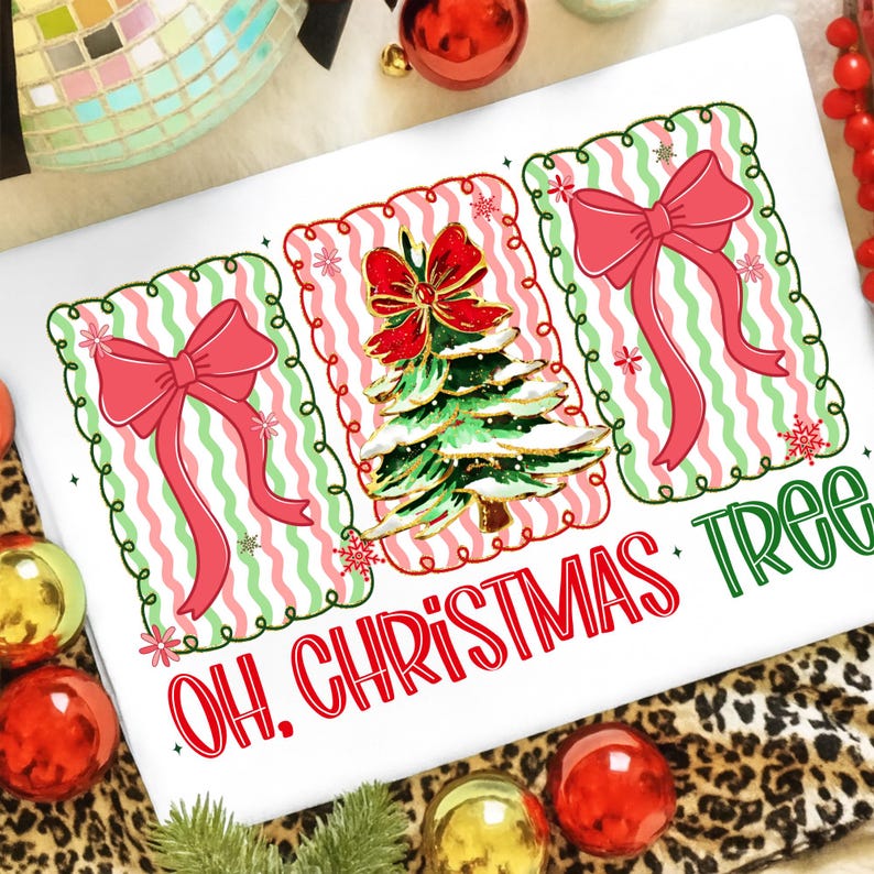 May include: White Christmas-themed graphic tee with three framed designs. The center frame features a Christmas tree with a red bow, flanked by two frames with pink bows. The text "OH. CHRISTMAS TREE" is printed in red and green.