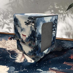 Könnte beinhalten: Ein quadratischer Taschentuchbox-Bezug mit japanischem Landschaftsdesign. Der Bezug zeigt eine Berglandschaft mit einem roten Torii-Tor, Bäumen und einem blau-weißen Farbschema. Der Taschentuchbox-Bezug hat eine rechteckige Öffnung.