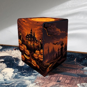 May include: A square deck box featuring a Halloween-themed illustration of a haunted mansion, a graveyard, and numerous orange pumpkins under a full moon. The box displays dark orange and black tones with detailed silhouettes of trees and bats.