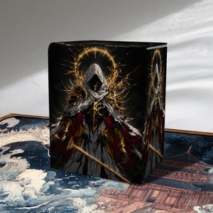 May include: A rectangular deck box featuring a dark illustration of a hooded figure in gold and black armour with a glowing halo, holding a sword. The box is set against a playmat depicting a traditional building amidst stylised waves and clouds.