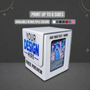 May include: A white rectangular deck box with a textured finish, featuring the text "YOUR DESIGN HERE" and "FREE PREVIEW" on the side. The front displays a clear window containing a trading card with a blue cat illustration and "ADD YOUR TEXT / NAME" above it.