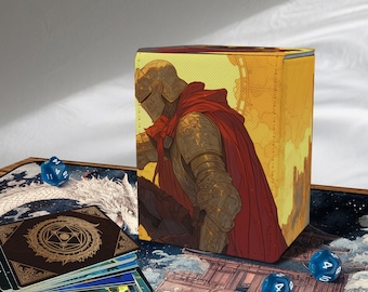 Puede incluir: Una caja de almacenamiento de cartas con un caballero con armadura dorada y una capa roja sobre un fondo de puesta de sol. También se ven dados azules y una baraja de cartas con un dragón y diseños geométricos. El tema es la fantasía.