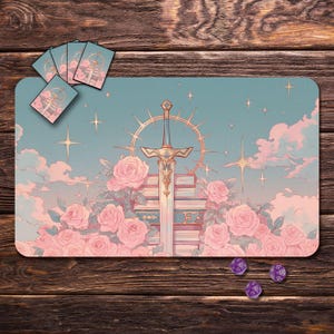 May include: A pastel playmat with a sword design, set against a backdrop of pink roses, clouds, and stars. The image includes matching card sleeves and dice. The design features a sword atop a stack of books.