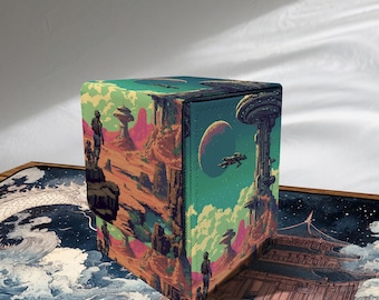 Puede incluir: Una caja de almacenamiento cúbica con un diseño de paisaje retro-futurista colorido. La obra de arte presenta un planeta con una gran luna, una estación espacial y figuras sobre un terreno rocoso. La caja es probablemente para guardar objetos pequeños.