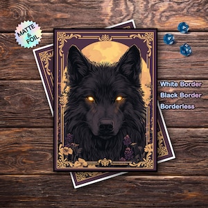 Op de afbeelding: Een illustratie van een zwarte wolf met heldergele ogen, tegen een volle maan en bloemmotieven. Het kunstwerk is omlijst met een gouden rand op een paarse achtergrond. De afbeelding is gelabeld met "Matte & Foil" en "White Border, Black Border, Borderless."