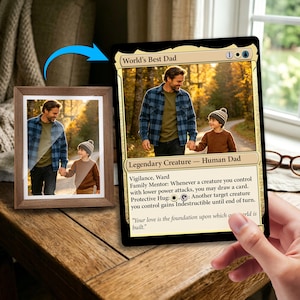 May include: A framed photograph and a collectible card featuring a father and child holding hands on a path. The card reads "World's Best Dad" and includes game text. The frame is brown.