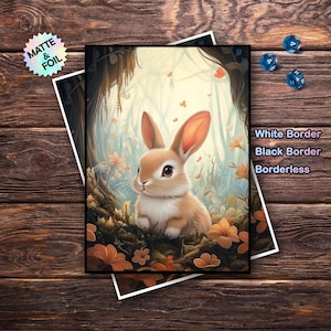 May include: A print featuring a brown and white bunny in a forest setting with orange flowers. The print has a black border and the text "White Border, Black Border, Borderless". A sticker on the left says "Matte & Foil".
