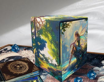 May include: A square, hinged card storage box with a fantasy art design. The box features a forest scene with a fairy and a tree. Blue dice and a deck of cards are visible.