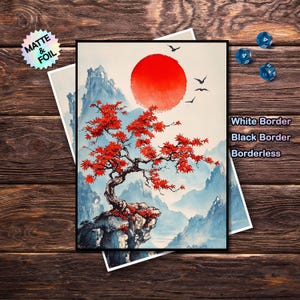 May include: An art print featuring a red sun, a bonsai tree with red leaves, and blue mountains. The print has a black border and the text "White Border, Black Border, Borderless". A holographic sticker that says "Matte & Foil" is in the upper left corner.