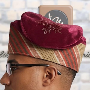 May include: A structured cap featuring a deep burgundy velvet top section adorned with small sparkling crystals. The lower band displays a diagonal striped pattern in shades of brown, tan, and orange. The cap is worn on the head, showing a side profile.