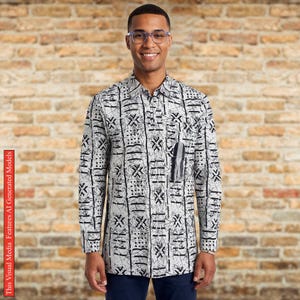 May include: A long-sleeved button-down shirt featuring a white base with a black abstract geometric pattern. The shirt includes a standard collar, a front button placket, and a single chest pocket adorned with a small, dangling grey tassel detail.