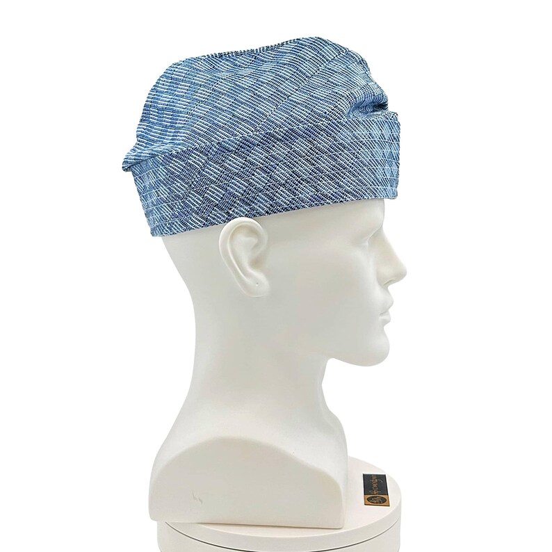 May include: A blue and white patterned hat with a brim, displayed on a white mannequin head. The hat has a textured appearance and is made of a woven fabric. The hat is a type of headwear.