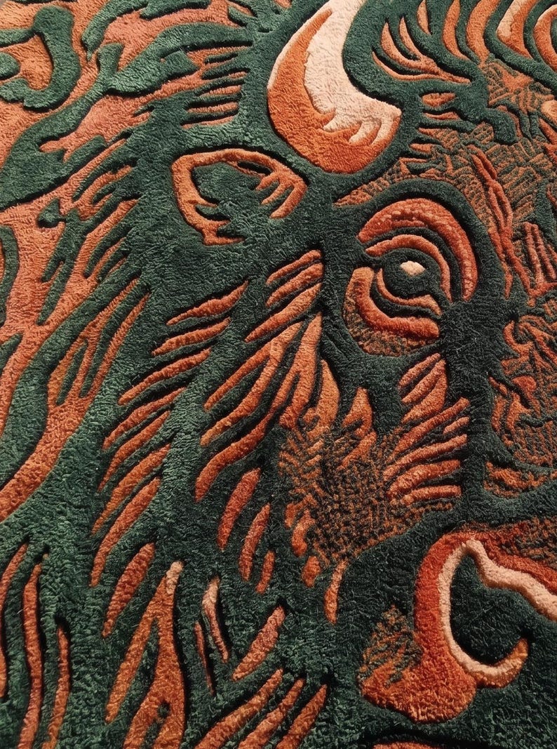Peut inclure: Gros plan sur un tapis avec un motif de bison. Le tapis pr&eacute;sente un motif d&eacute;taill&eacute; dans des tons de vert et d'orange, avec la t&ecirc;te et les cornes du bison bien en &eacute;vidence. Le motif a un aspect textur&eacute; et sculpt&eacute;.
