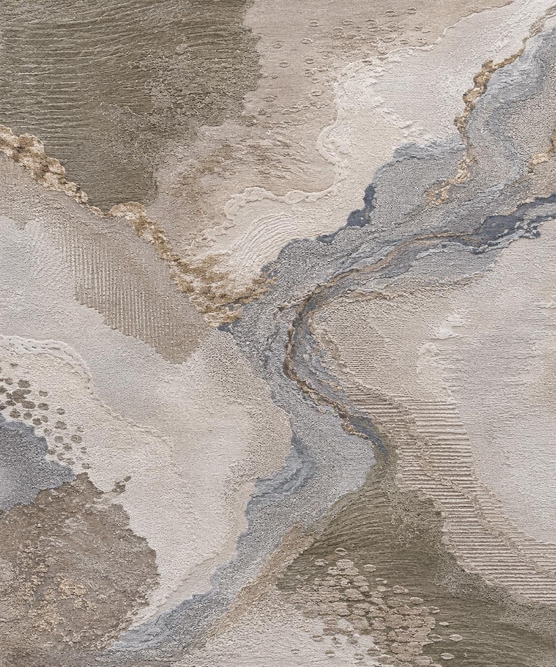 May include: A textured abstract wall art piece featuring a layered composition of beige, taupe, gray, and metallic gold tones. The surface displays varied tactile patterns including raised ridges, fine lines, and stippled areas creating depth.