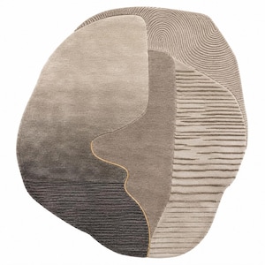 May include: An irregularly shaped area rug featuring a palette of taupe, beige, and dark gray. The surface displays varied textures, including smooth sections, horizontal ribbed lines, and a swirling, fingerprint-like pattern in the upper right corner.