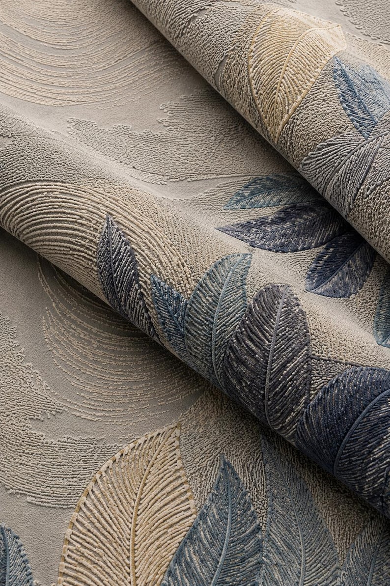 Op de afbeelding: Close-up van getextureerd behang met een herhalend veermotief. De veren zijn in tinten blauw, beige en grijs, waardoor een gelaagd effect ontstaat. De achtergrond heeft een subtiel, wervelend patroon. Geschikt voor interieurdecoratie.