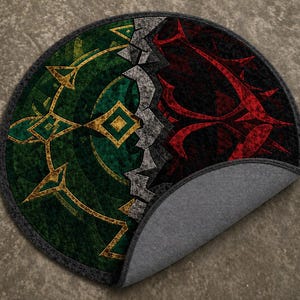 Hand tufted round wool and Tencel rug with green and red abstract split design, folded to show backing and thickness on neutral floor