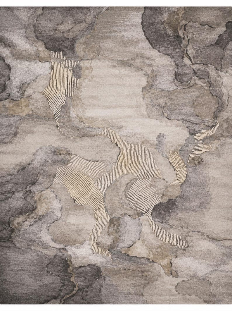 May include: A rectangular area rug featuring an abstract pattern of swirling gray, charcoal, and beige clouds. The design incorporates distinct sections of cream-colored parallel lines that contrast with the soft, blended textures of the background.