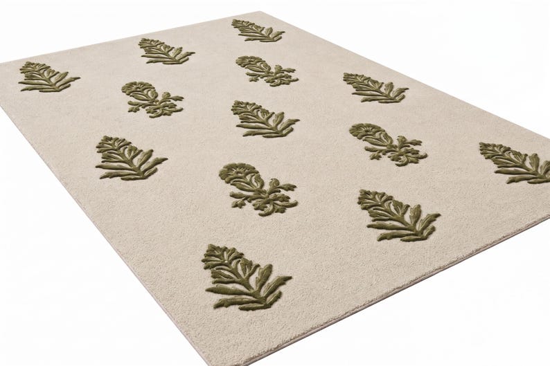May include: A rectangular area rug featuring a light cream-colored base with a repeating pattern of raised, olive green floral motifs. The design consists of stylized botanical shapes arranged in a grid-like formation across the surface.