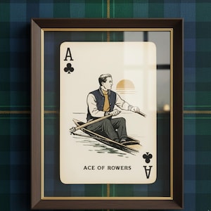 May include: Framed playing card art featuring the Ace of Clubs with an illustration of a person rowing a boat at sunset. The card is framed in a dark brown frame with a gold inner border, set against a plaid background.