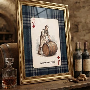 May include: A framed wall art piece featuring a playing card design with a person in an apron working on a wooden barrel. The card is labeled Jack of the Cork and is set against a blue and grey plaid background inside a gold beaded frame.