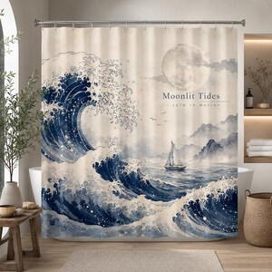 May include: A shower curtain featuring a large, dark blue crashing wave on the left, a sailboat on the water, and a full moon in the sky. The text "Moonlit Tides" and "in calm in motion" is printed in the center. The background is cream-colored.