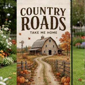 May include: A rectangular garden flag featuring the text "COUNTRY ROADS TAKE ME HOME" in dark brown letters. The illustration depicts a rustic wooden barn, a windmill, and a dirt path lined with wooden fences, pumpkins, and autumn leaves.