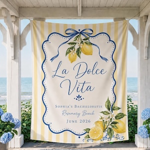 May include: A rectangular fabric banner featuring vertical yellow and white stripes. The center displays a blue decorative border, lemon illustrations with green leaves, and the text La Dolce Vita, Sophia's Bachelorette, Rosemary Beach, June 2026.