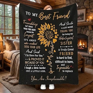 May include: Black blanket with a sunflower design and text that reads "To My Best Friend." The blanket has a rustic, cozy aesthetic, with a fireplace and wooden furniture in the background. The text includes phrases about friendship.