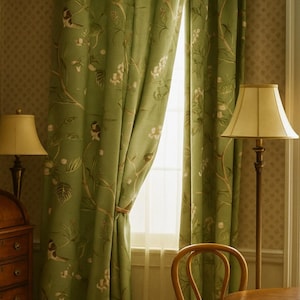 Puede incluir: Cortinas verdes con estampado floral y una cinta de sujeción marrón claro. Se ve una ventana y una lámpara de pie con una pantalla beige. La habitación tiene un ambiente cálido y acogedor.