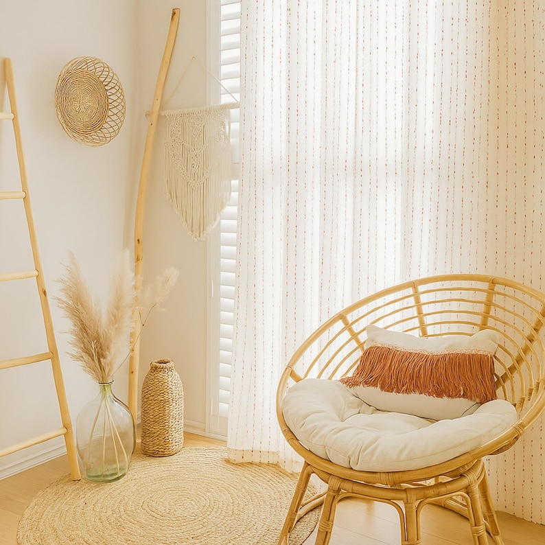 Puede incluir: Un interior acogedor de estilo bohemio con una silla redonda de rat&aacute;n, un coj&iacute;n blanco y una almohada con flecos. Una alfombra tejida, un jarr&oacute;n decorativo con hierba de la pampa y una escalera de madera se suman a la est&eacute;tica natural de la habitaci&oacute;n. Un tapiz de pared tejido y una decoraci&oacute;n de pared redonda completan el look.