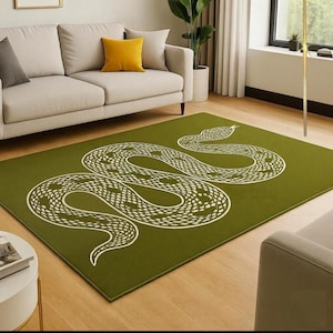 Pode incluir: Um tapete retangular com um fundo verde-oliva sólido e uma grande ilustração de uma serpente branca estilizada centrada na superfície. A serpente é representada numa posição sinuosa em forma de S com padrões de escamas detalhados.