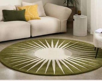 May include: A round olive green rug with a white sunburst design. The rug is placed in front of a white sofa with green and yellow throw pillows. A white chair and side table are also in the room.