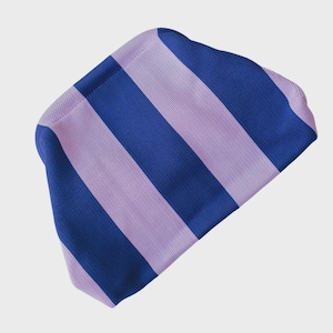 May include: A knit beanie featuring a bold, repeating pattern of wide vertical stripes in alternating shades of royal blue and light lavender. The fabric has a distinct, textured, and uniform knit construction throughout the entire accessory.