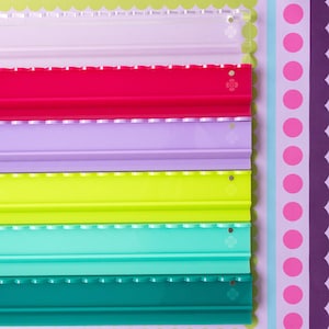 May include: A set of six rectangular acrylic display rails arranged vertically. The rails are clear, hot pink, light purple, lime green, turquoise, and dark teal. Each rail features a scalloped top edge and a small circular logo imprint.