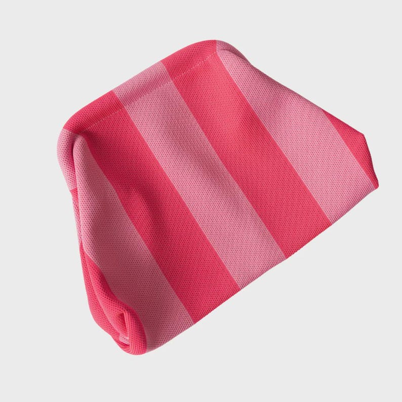 May include: A soft, fabric pouch featuring a repeating vertical striped pattern in alternating shades of bright hot pink and light pastel pink. The pouch has a structured, slightly curved top opening and a textured, woven knit-like appearance.