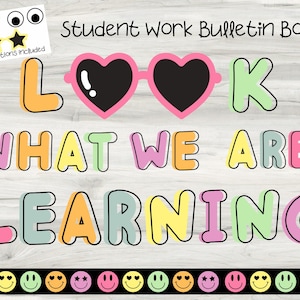 May include: A colorful bulletin board design with the text "LOOK WHAT WE ARE LEARNING". The word "LOOK" features heart-shaped sunglasses. Includes additional decorative elements like sunglasses, stars, and smiley faces.