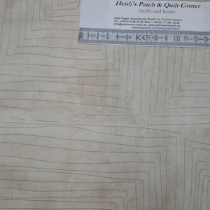 Könnte beinhalten: Ein beigefarbener Stoff mit einem geometrischen Muster aus dünnen schwarzen Linien, die Quadrate und Rechtecke bilden. Ein Lineal liegt auf dem Stoff und misst 38 cm.