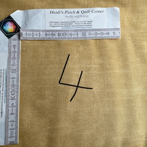 Może przedstawiać: Zbliżenie na linijkę z napisem "4" napisanym czarnym markerem na beżowym tle z tkaniny. Linijka jest oznaczona w centymetrach i calach. Tekst na wizytówce brzmi "Heidi's Patch & Quilt Corner, Stoffe und Kurse".