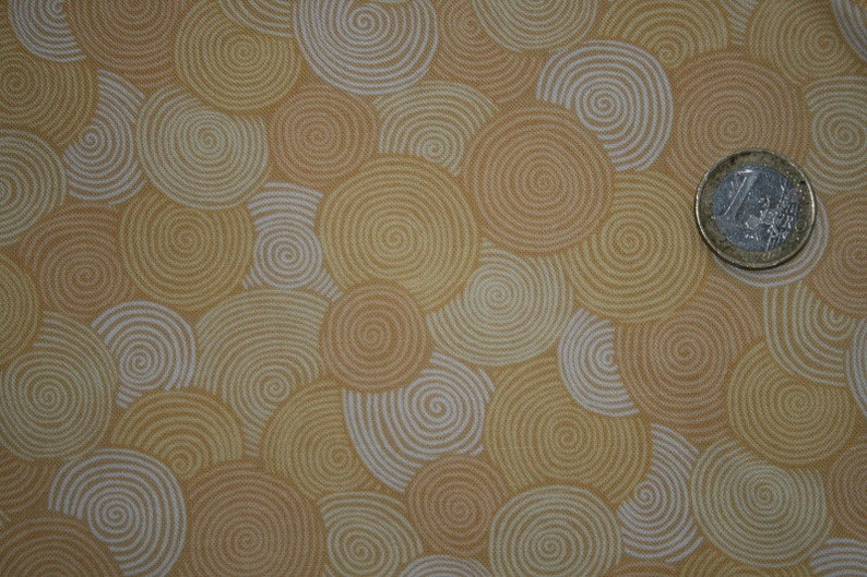 May include: A fabric with a repeating pattern of beige and white concentric circles.