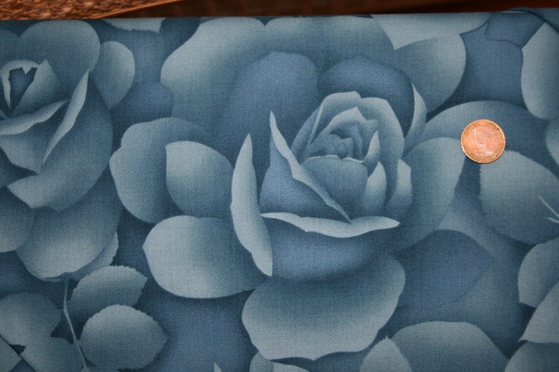 Pu&ograve; includere: Un tessuto blu con una stampa floreale a grande scala di rose. Le rose sono di colore blu chiaro e hanno un aspetto sbiadito e vintage.