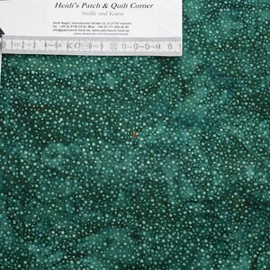 Puede incluir: Un primer plano de tela de color verde azulado con un patrón de lunares blancos. La tela es texturizada y tiene un sutil efecto degradado. La tela se mide con una regla en pulgadas.