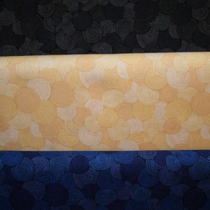 May include: Three fabric swatches with a swirling pattern. The top swatch is black, the middle swatch is yellow, and the bottom swatch is blue.