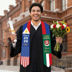 Könnte beinhalten: Ein lächelnder Absolvent in schwarzer Robe hält eine Urkunde und einen Blumenstrauß. Der Absolvent trägt eine Abschluss-Schärpe mit dem Text "Class of 2026" und dem Design der amerikanischen Flagge. Die Schärpe bietet auch Platz für den Schulnamen und das Wappen.